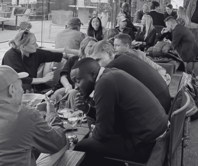 Black and white photo of AI BAREN guests in conversation around a table.