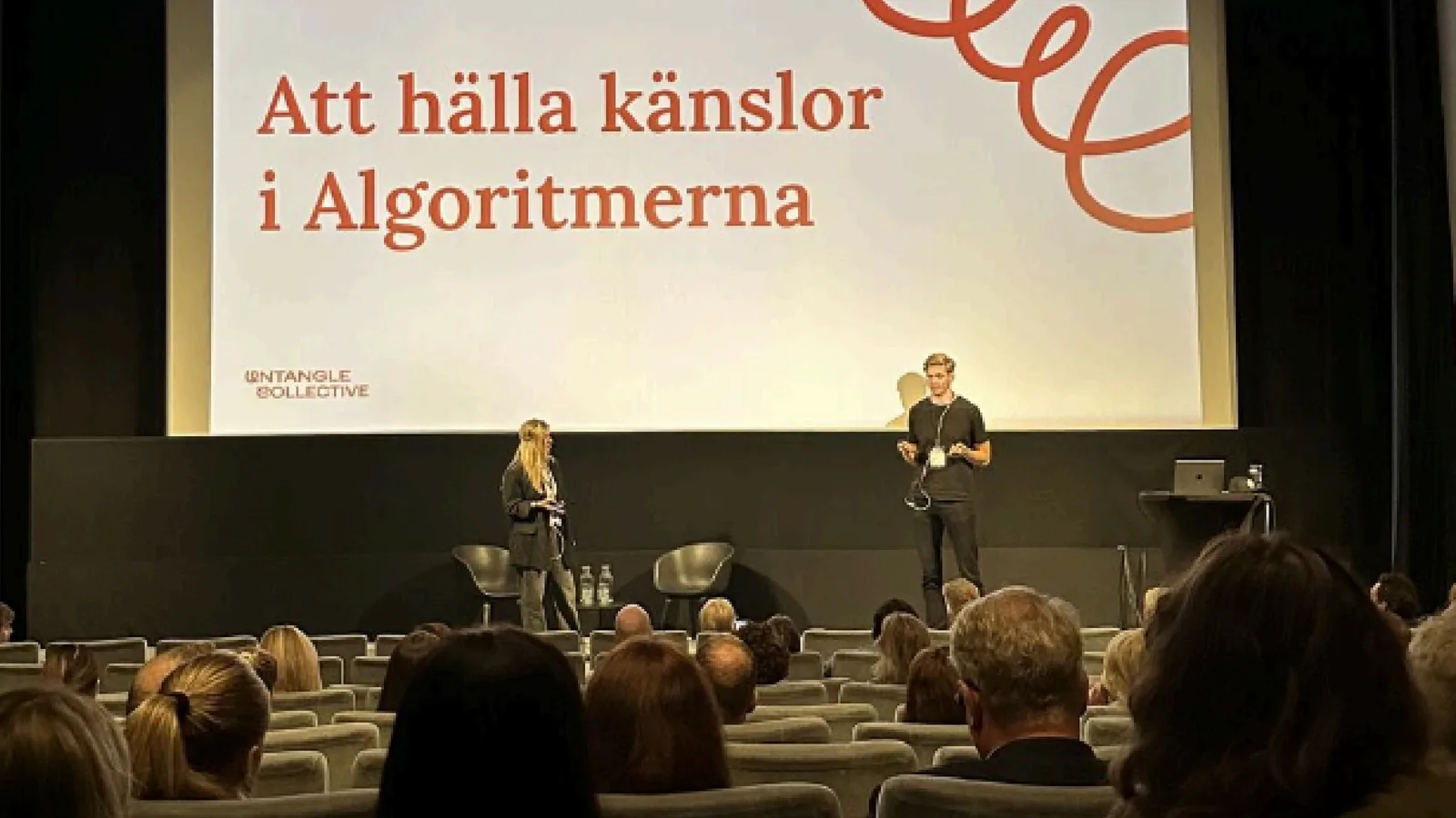 Sophia Båge and Lucas Östergren on stage presenting Untangle Collective.